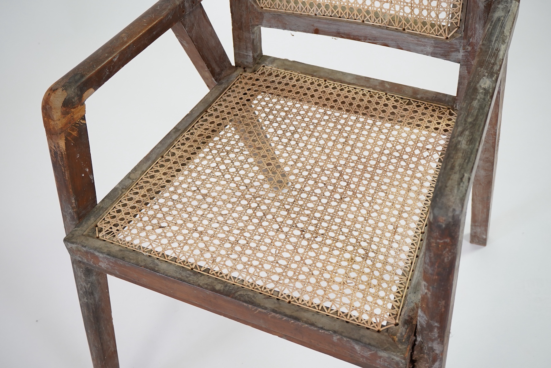 Manner of Pierre Jeanneret (Swiss, 1896-1967): A solid teak and braided canework armchair